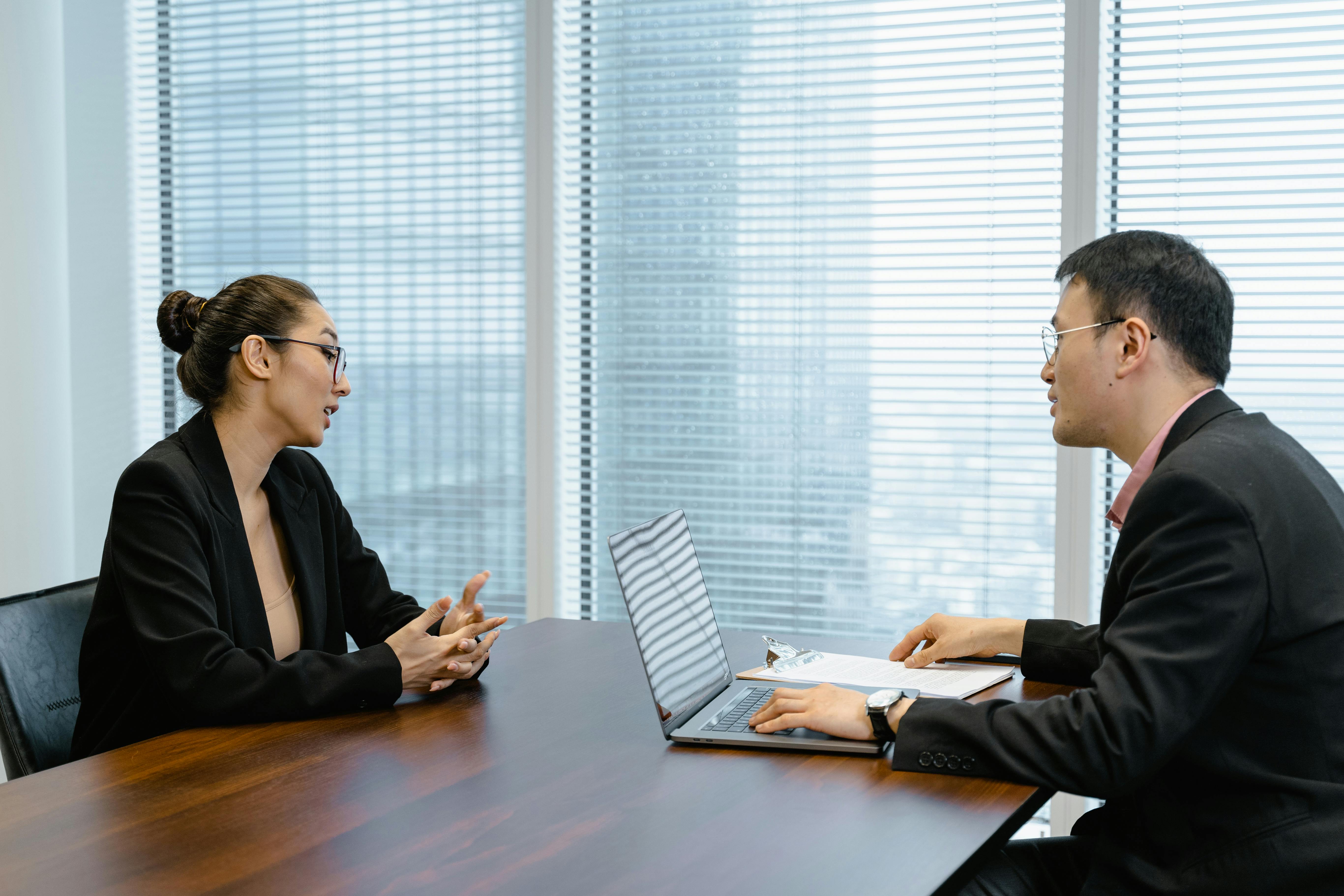 Two professionals discussing a project across a meeting table